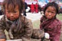 Two cute nomadic children - a brother and a sister outside the Monlam tent